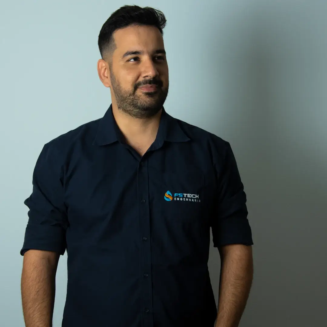 Homem sorridente vestido com camisa da FS Tech Engenharia, aparecendo confiante e profissional em fundo claro, representando a imagem da empresa.